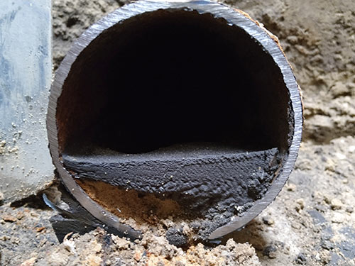 Ablagerungen hemmen Durchfluss in Kanälen und Rohren verengtes Rohr